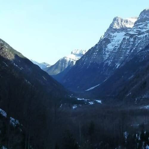 Imagen de un valle en Aragón con montañas de cumbres nevadas