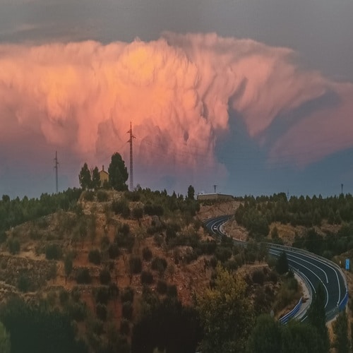 cerro con olivos junto a la carretera y caseta en lo alto