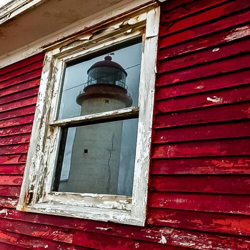 Faro reflejado en los cristales de una ventana